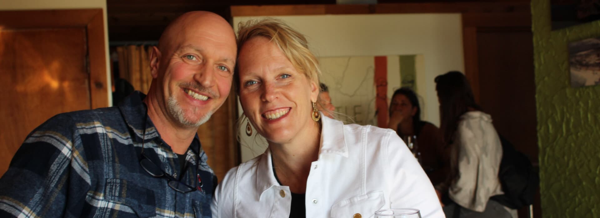 A smiling couple poses together in a cozy indoor setting.