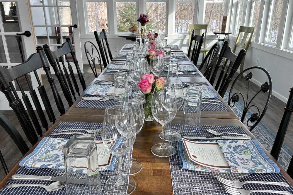 A beautifully set dining table with floral centerpieces, glassware, and place settings.