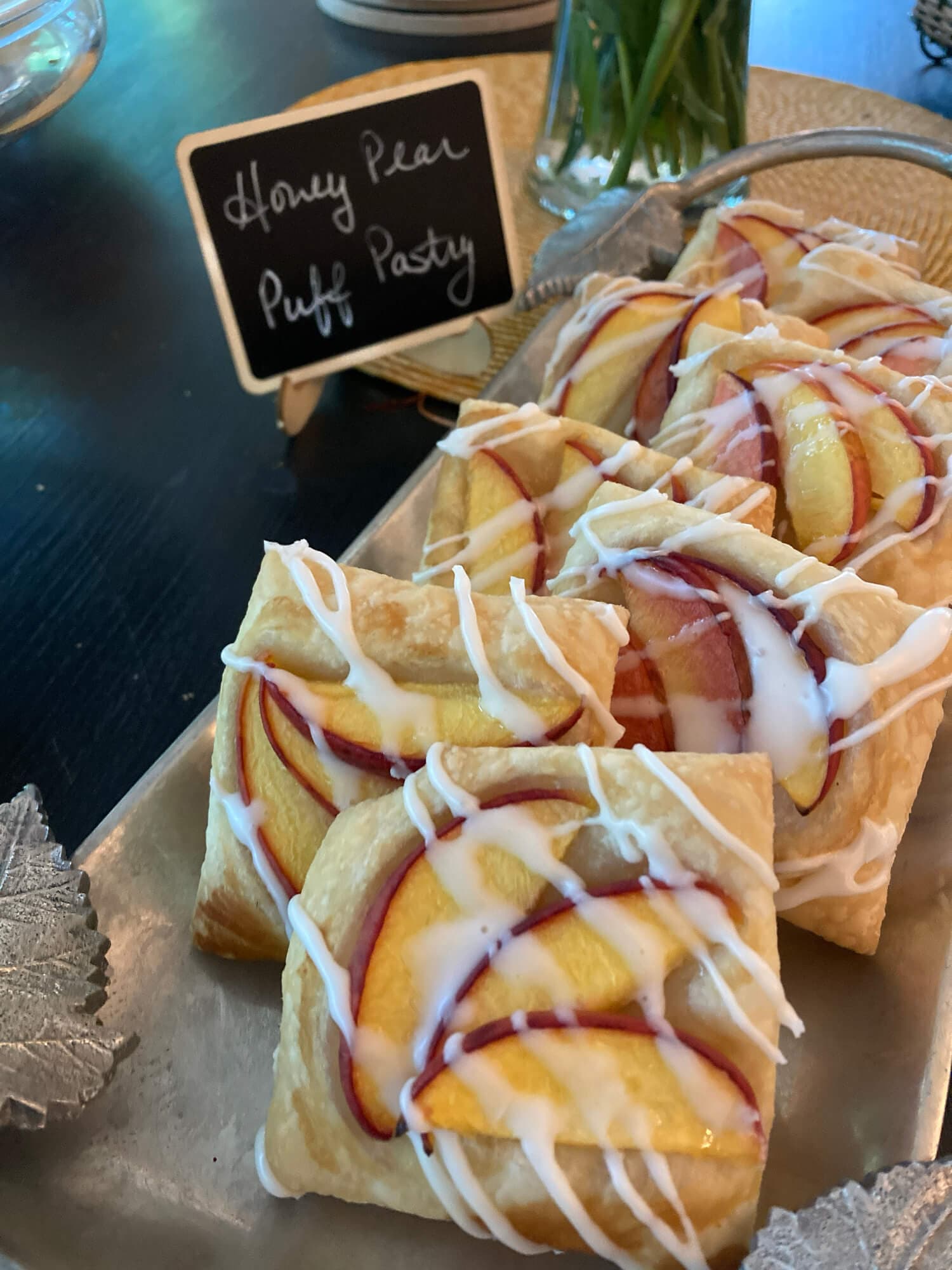 A plate of honey pear puff pastries drizzled with icing.