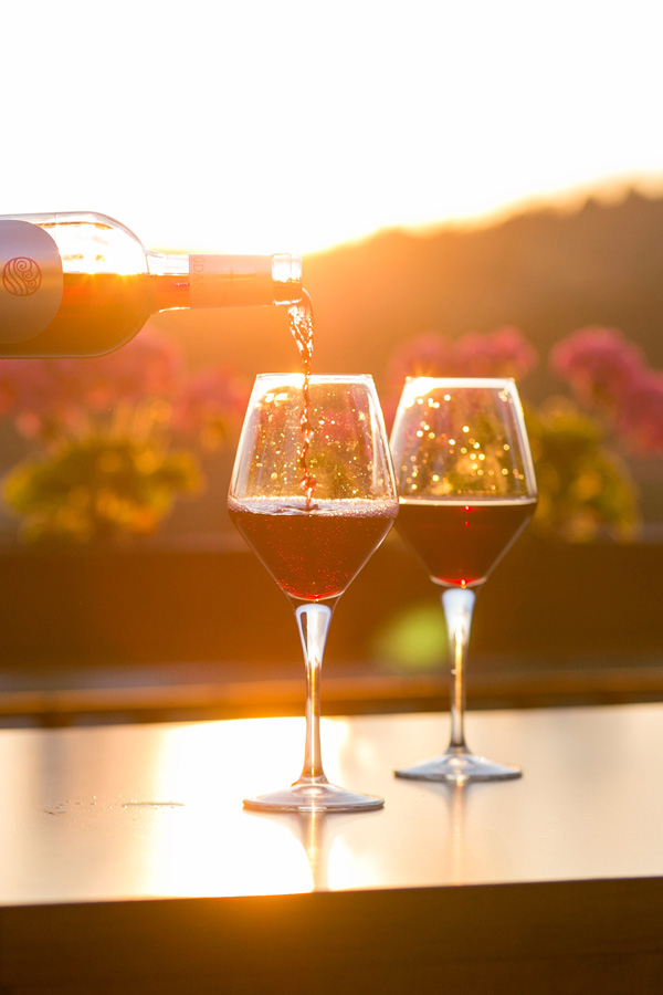 pouring wine into glasses at sunset