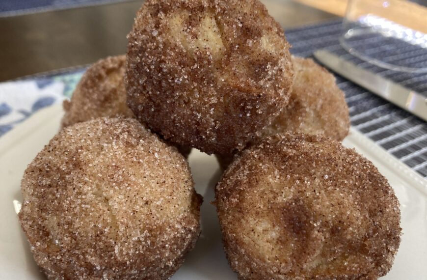 cinnamon sugar coated muffins stacked on white plate